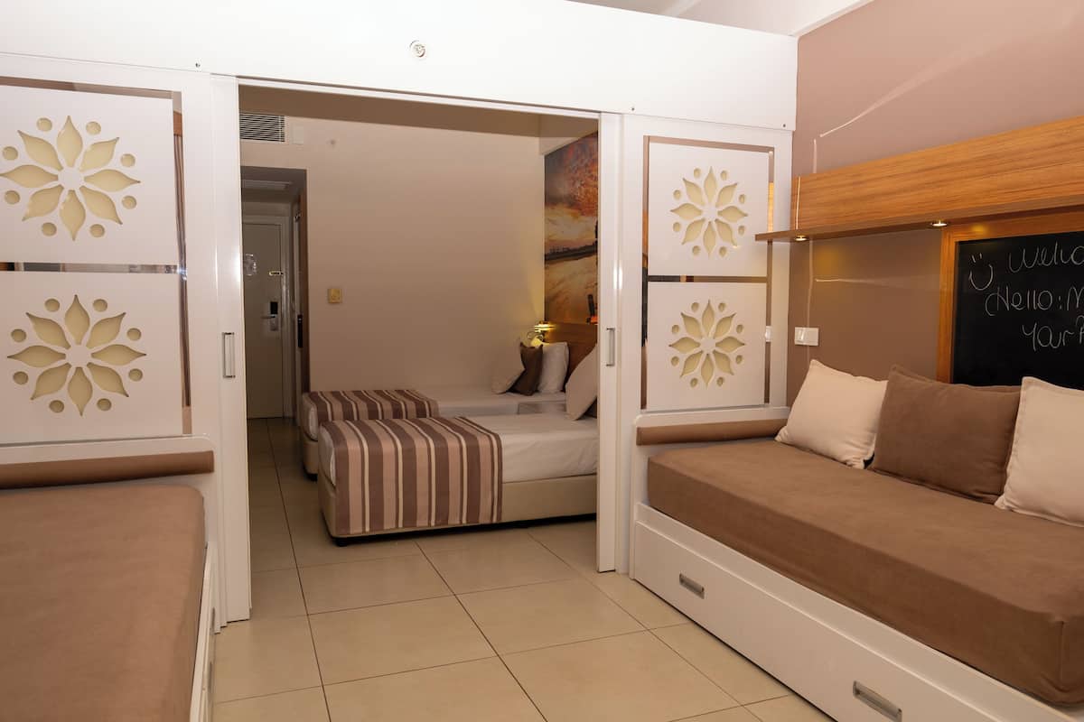 Une chambre à coucher comprenant un lit, un canapé et un panneau décoratif mural.