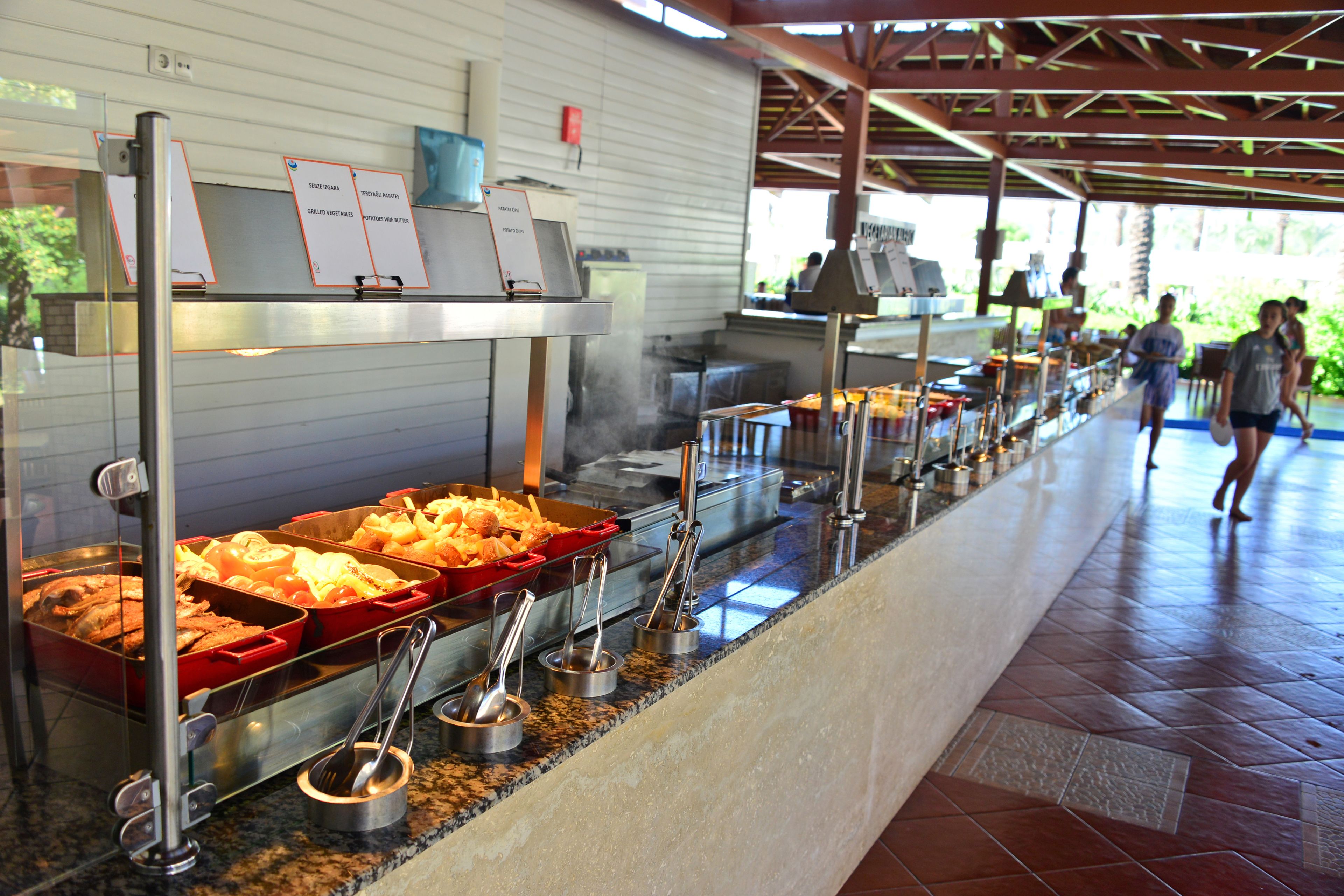 A buffet setup with various food items and serving utensils.