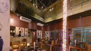 A restaurant interior with high ceilings, exposed ductwork, and a mix of traditional and modern decor. - Hotel Agrabad (Chittagong)