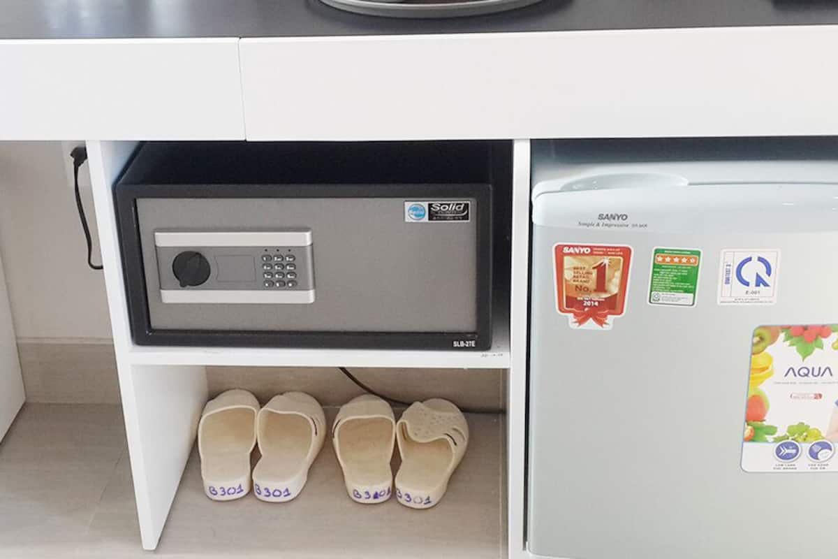 Una cocina con microondas incorporado, un refrigerador con imanes y calcomanías, y un par de pantuflas en el suelo.