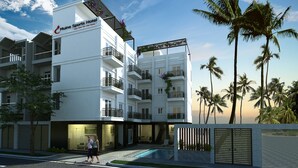 A modern hotel with multiple balconies, a swimming pool, and palm trees in the background. - Mui Ne Sports Hotel (Mui Ne)