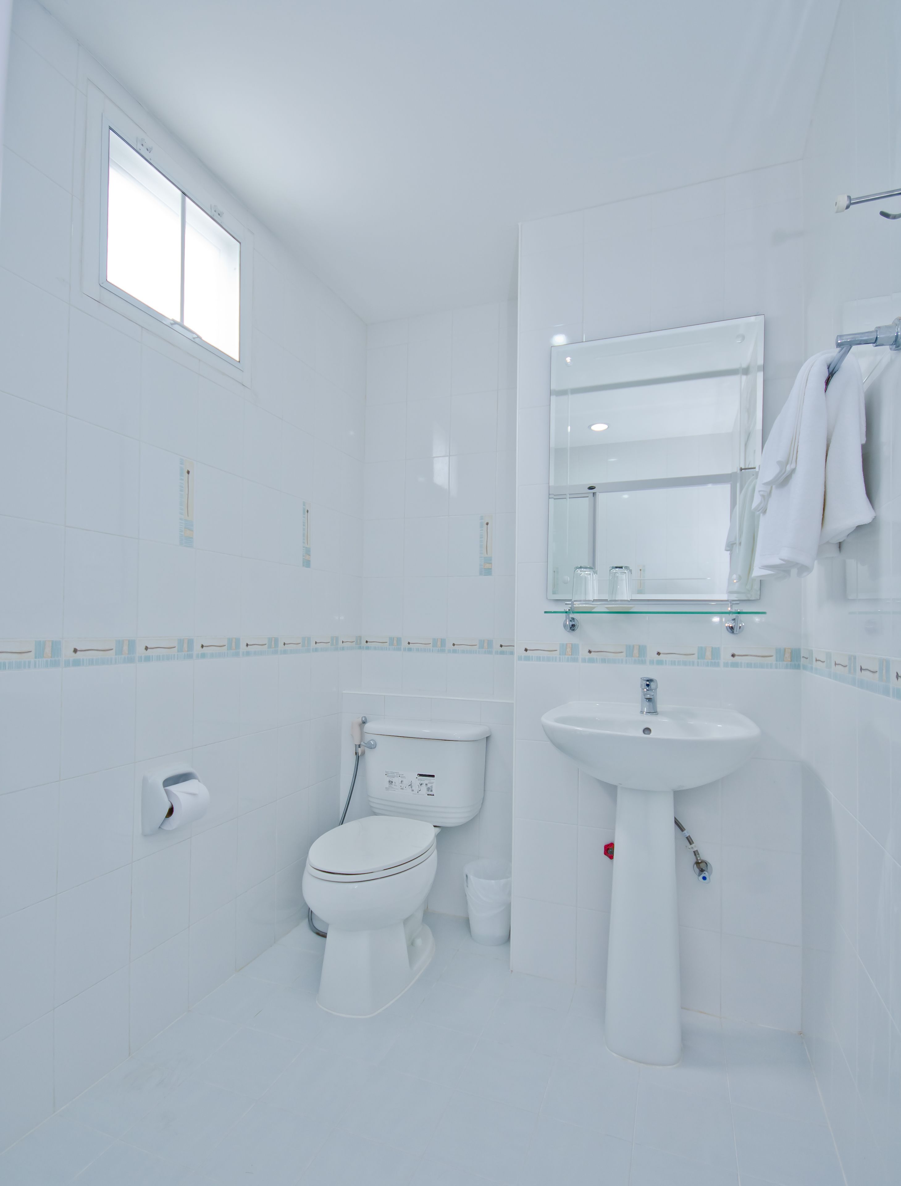 A modern bathroom with a toilet, sink, and mirror.