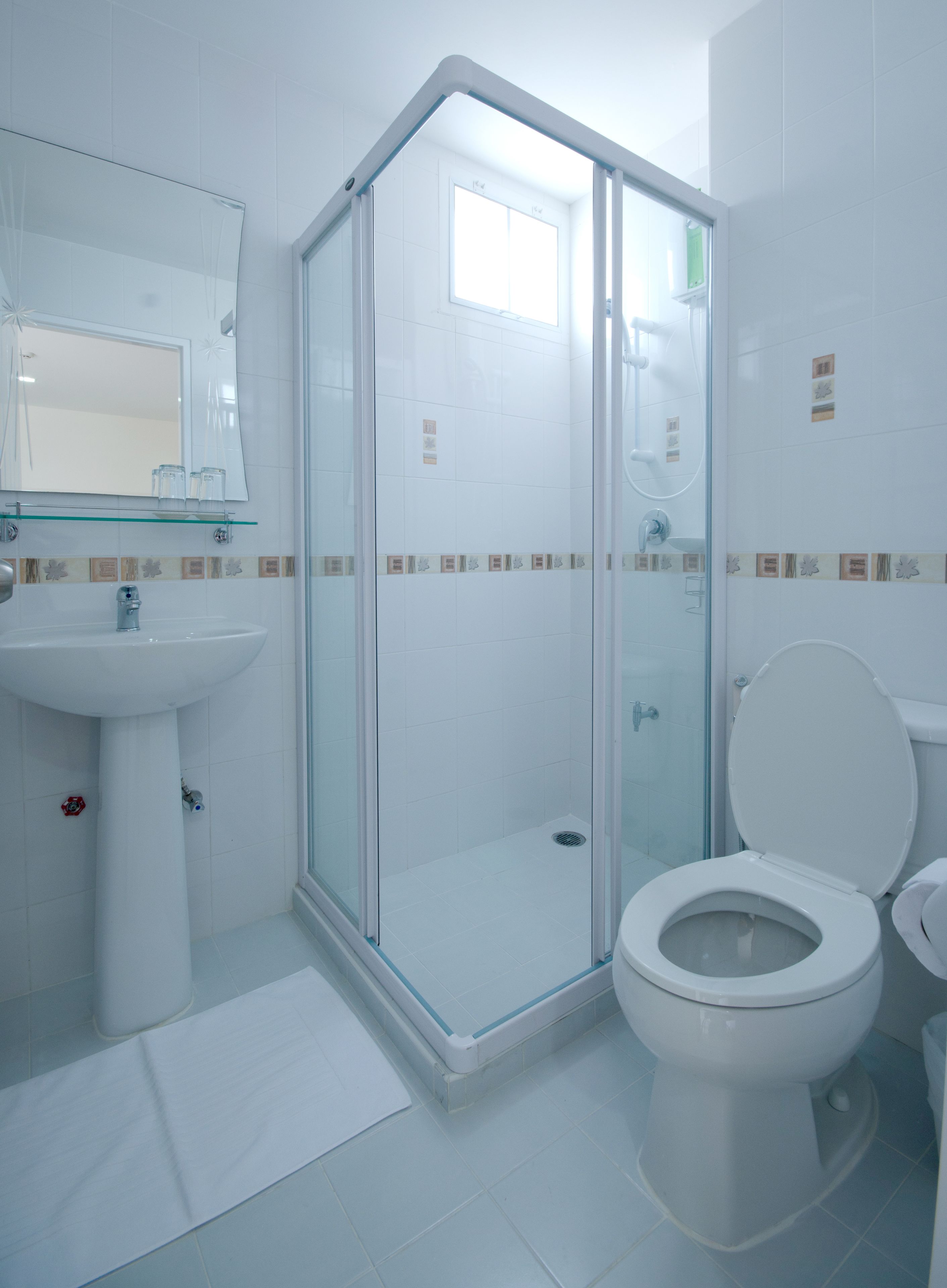 A modern bathroom with a glass shower enclosure, a white sink, and a toilet.