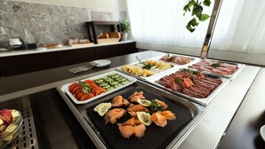 A buffet with various food options including smoked salmon, vegetables, and meats.