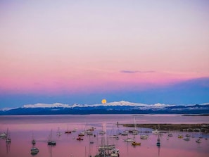 A calm body of water with boats and a mountain range in the background. - Hotel Monaco (Ushuaia)