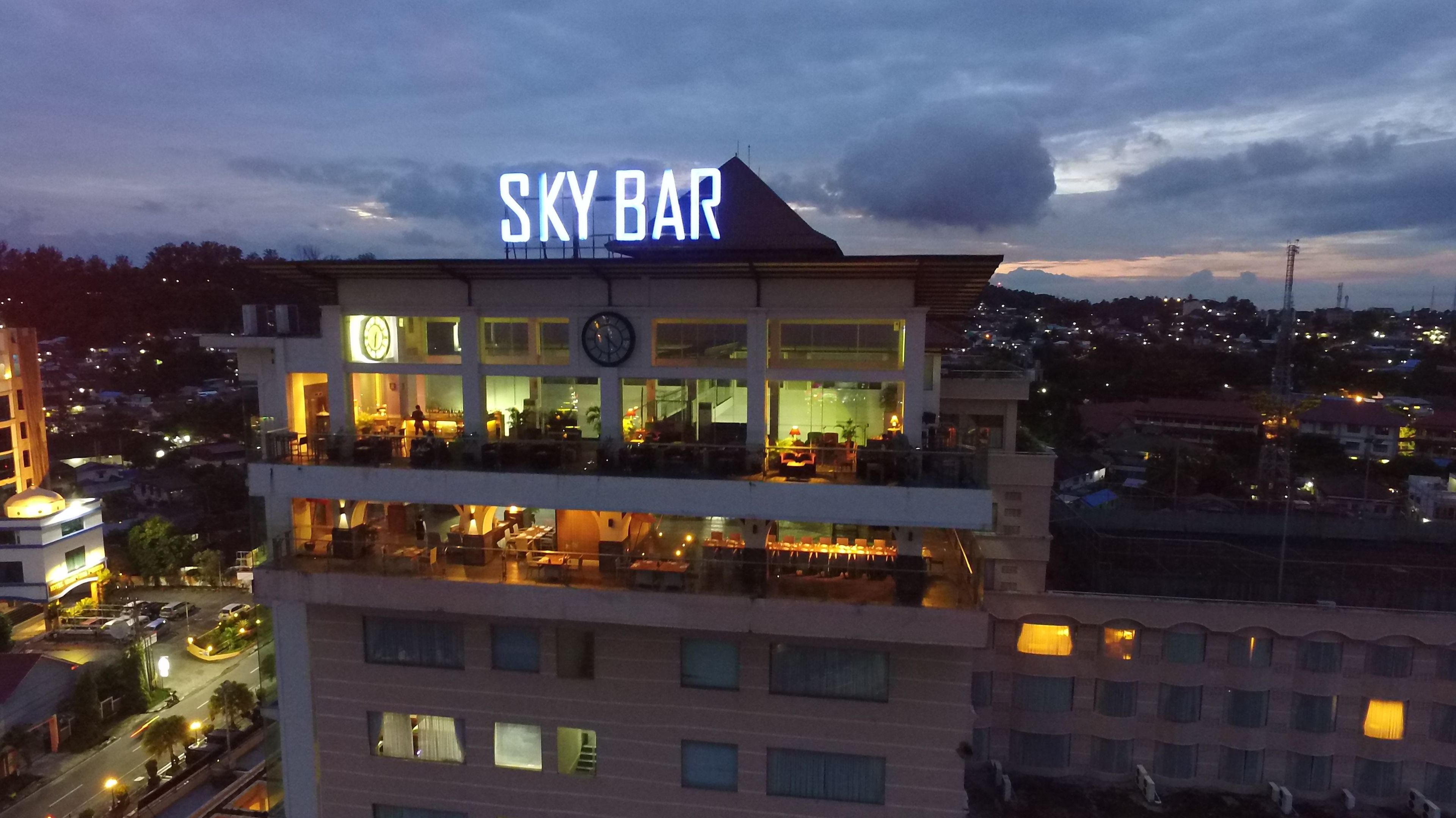 Un hotel con un llamativo letrero que dice "SKY BAR" en la azotea.