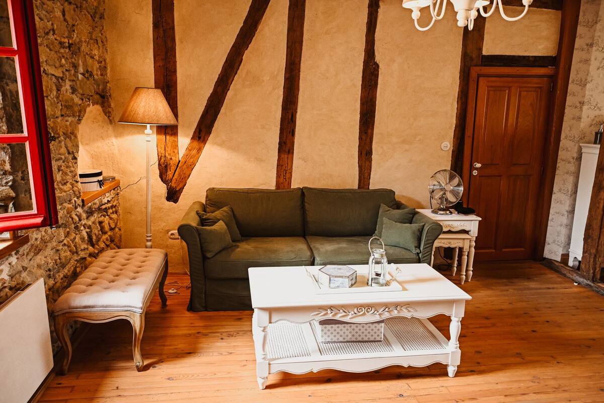 A cozy living room with a green sofa, a white coffee table, a bench, and a lamp.