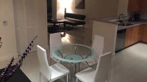 Une cuisine compacte comprenant un coin repas, un banc et une petite table avec des chaises.