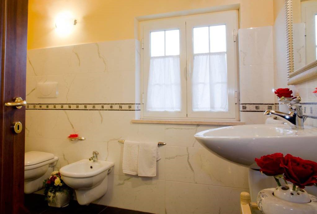 A bathroom with a toilet, bidet, and sink.