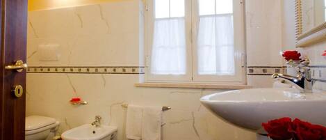 A bathroom with a toilet, bidet, and sink.