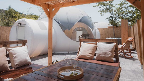 An outdoor patio with wooden furniture and a table, surrounded by a wooden pergola. - Fuente del Lobo Glamping  Bungalows - Adults Only (Pinos Genil)