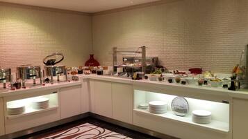 A buffet setup with various food items and condiments.