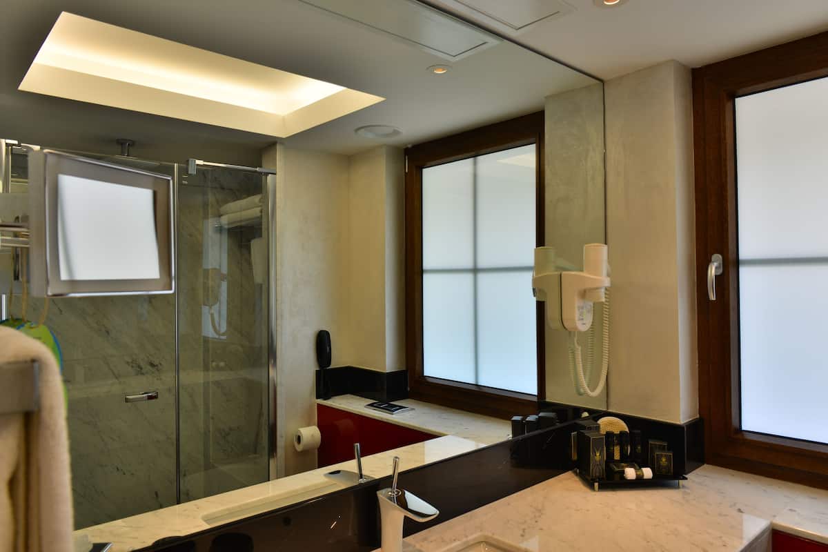 executive deluxe king room | bathroom | rainfall showerhead, designer toiletries, hair dryer, slippers