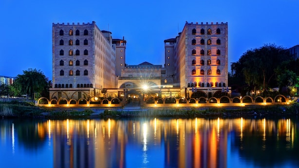 A historic building with a symmetrical facade, arched entrance, and a reflection in the water. - Suhan Cappadocia Hotel & Spa (Avanos)