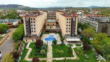 A hotel with a central courtyard, a swimming pool, and a view of the surrounding cityscape.