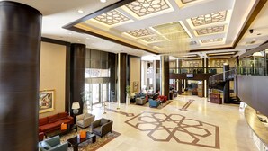 A spacious lobby with a high ceiling, modern furniture, and a central staircase. - Suhan Cappadocia Hotel & Spa (Avanos)