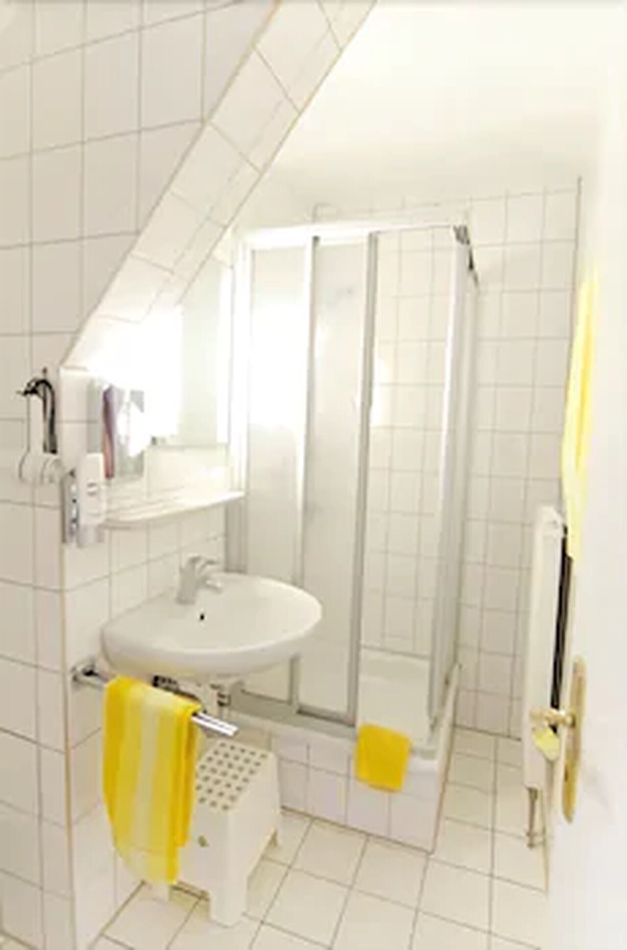 Ein Badezimmer mit Waschbecken, Spiegel und Dusche.
