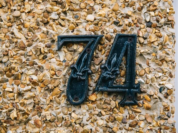 A number '74' in a decorative metal sign on a pebble-textured wall. - Brinkburn Serviced Apartments (Darlington)