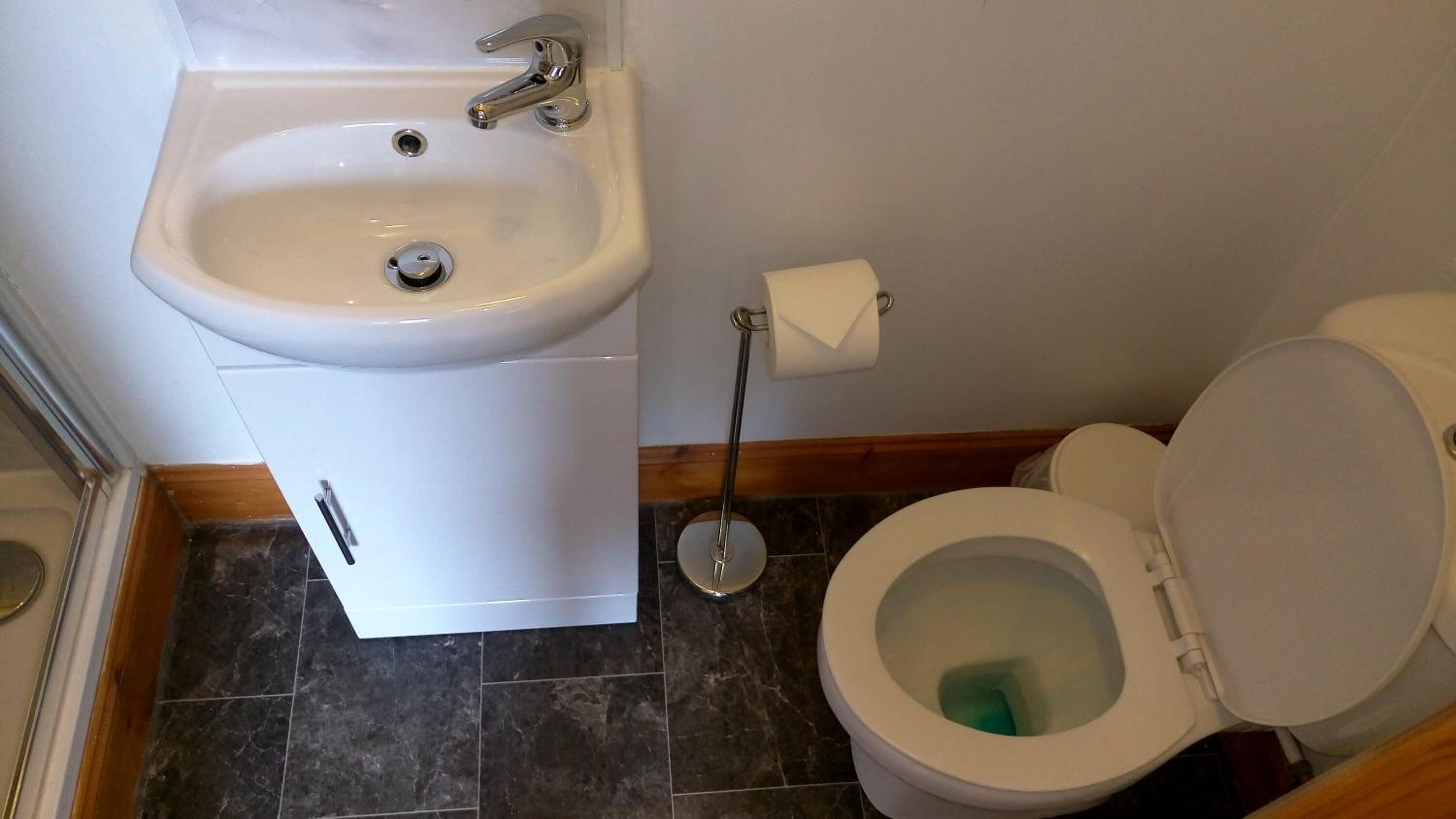 Ein Badezimmer mit weißem Waschbecken, WC und Bidet.
