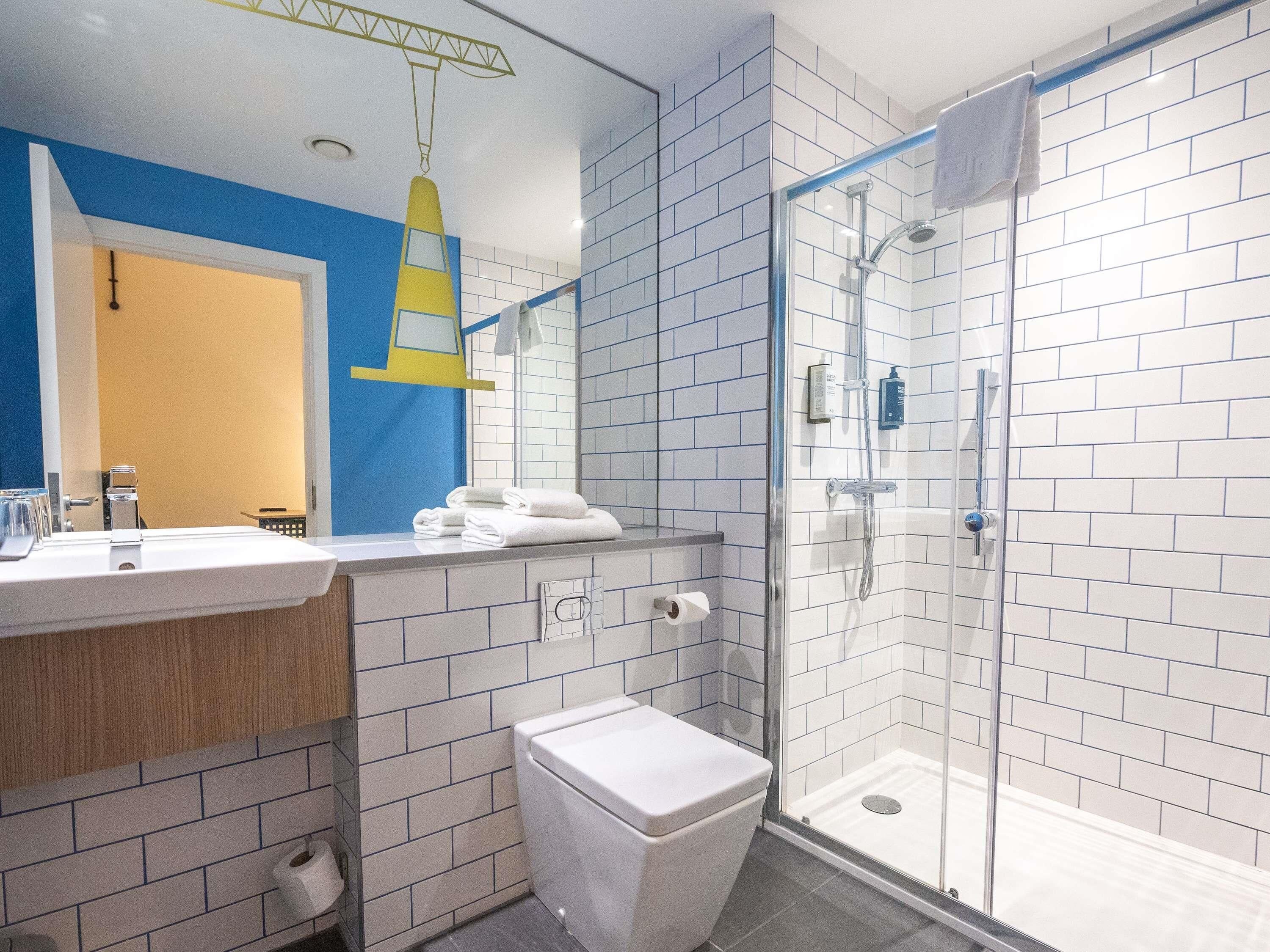 A modern bathroom with a shower, toilet, and sink.