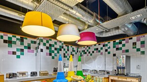 A buffet setup with a checkered tablecloth, various food items, and colorful hanging lamps. - Ibis Styles Glasgow Centre George Square (Glasgow)