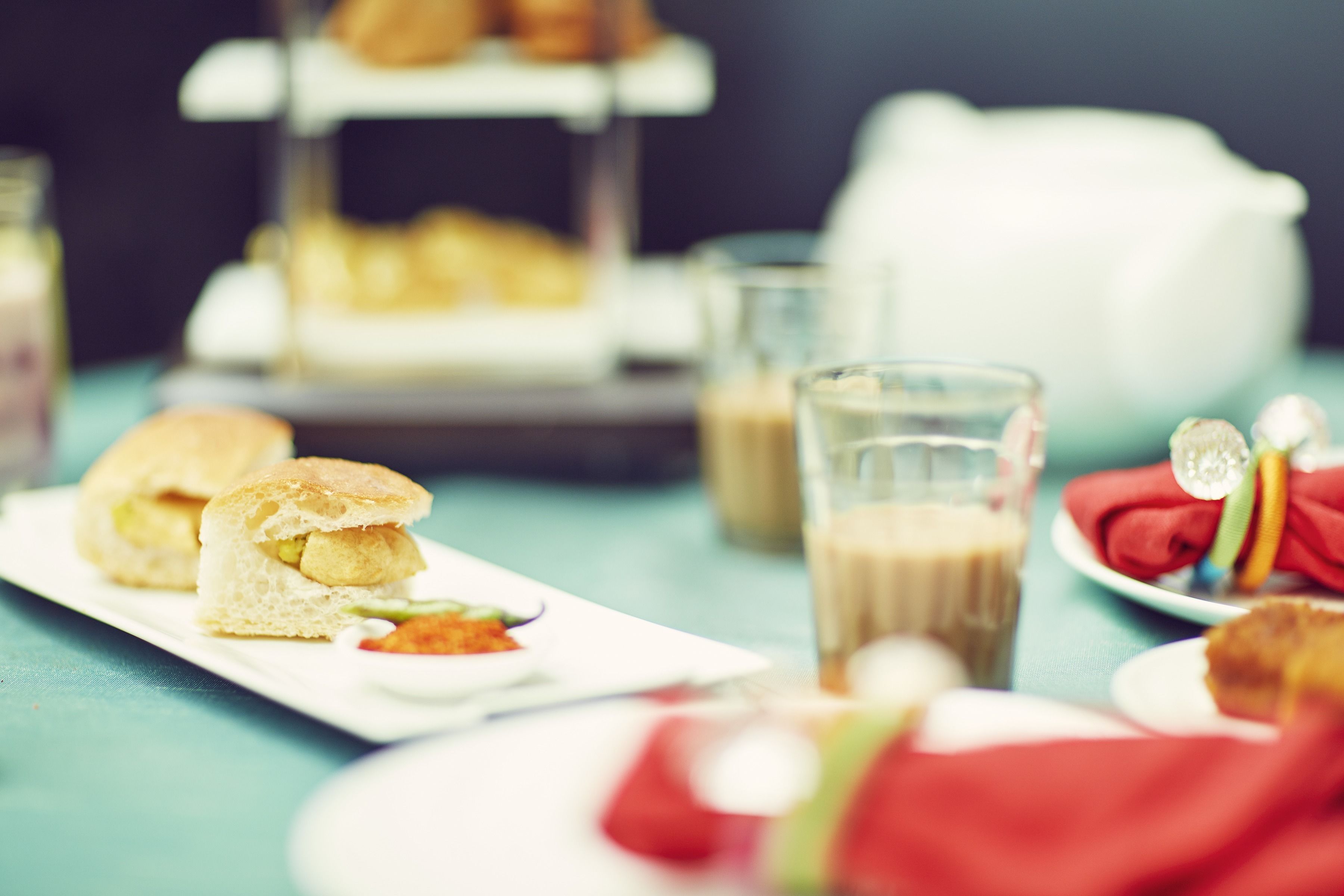 A table with a sandwich, a glass of milk, and a plate with a red napkin.