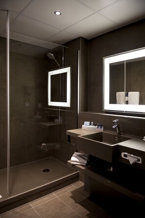 A modern bathroom with a glass-enclosed shower, a vanity with a mirror, and a sink. - Novotel Amsterdam Schiphol Airport (Hoofddorp)