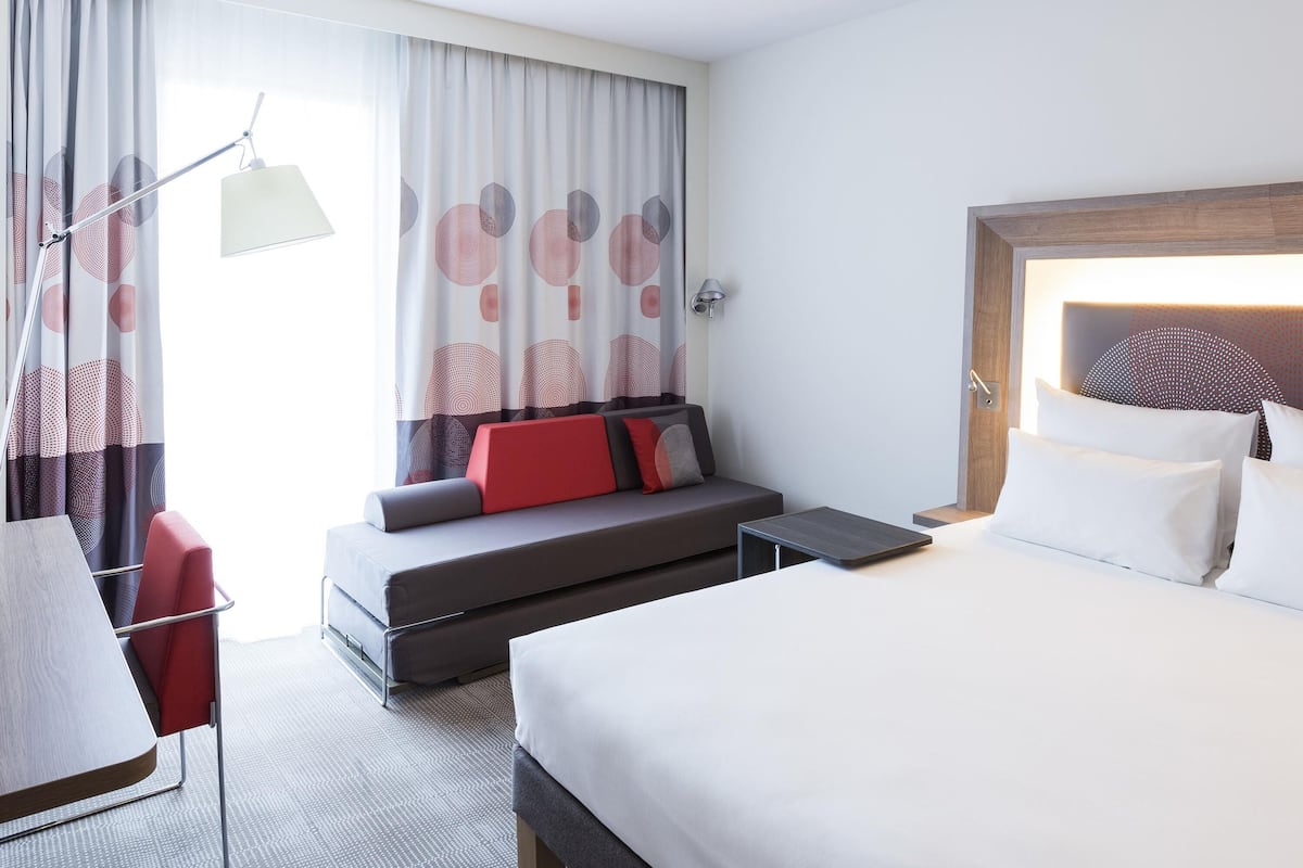 Una habitación de hotel con cama, sofá, escritorio y silla.