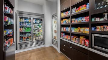 Un espace bien aménagé avec un réfrigérateur rempli de boissons et de collations variées.