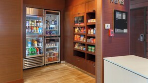 A corner market with refrigerated beverage dispensers and snack shelves.