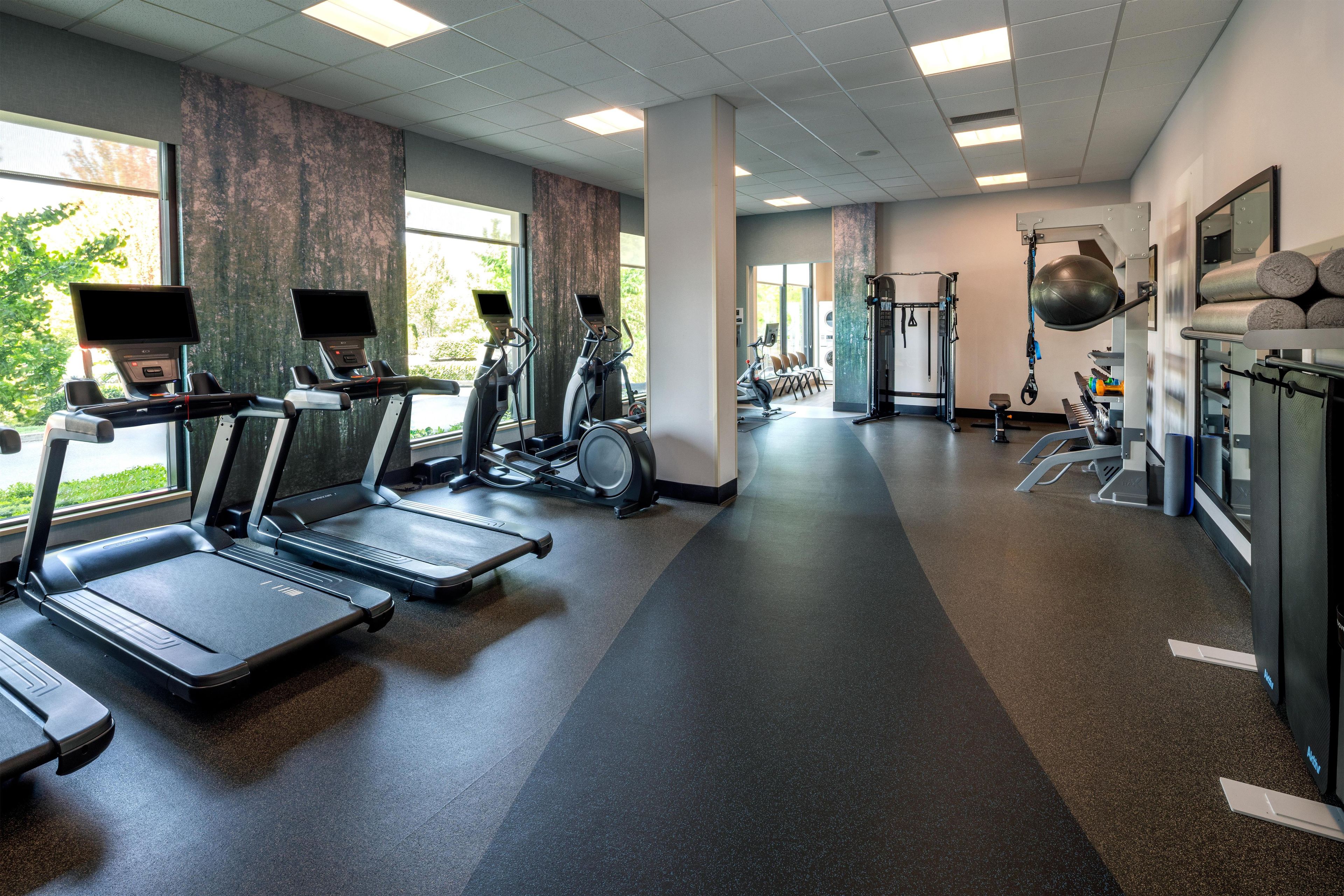 A gym with treadmills, elliptical machines, and weightlifting equipment.