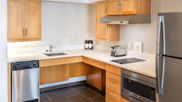 Een moderne keuken met houten kastjes, roestvrijstalen apparatuur en een vaatwasser.