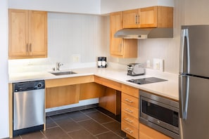 A modern kitchen with wooden cabinets, stainless steel appliances, and a dishwasher.