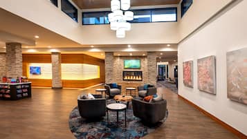 A spacious lobby with a fireplace, seating area, and artwork on the walls.
