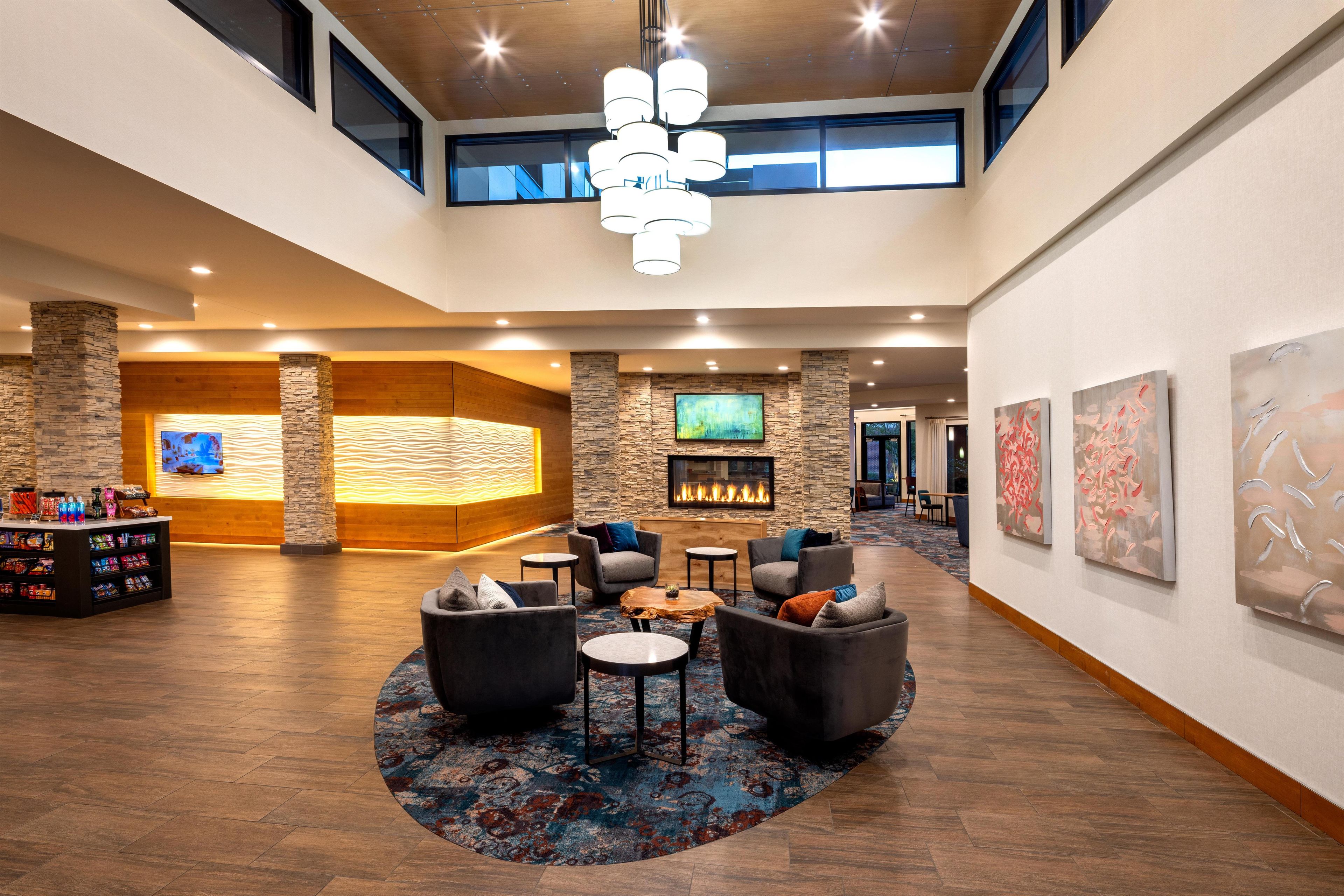 A spacious lobby with a fireplace, seating area, and artwork on the walls.