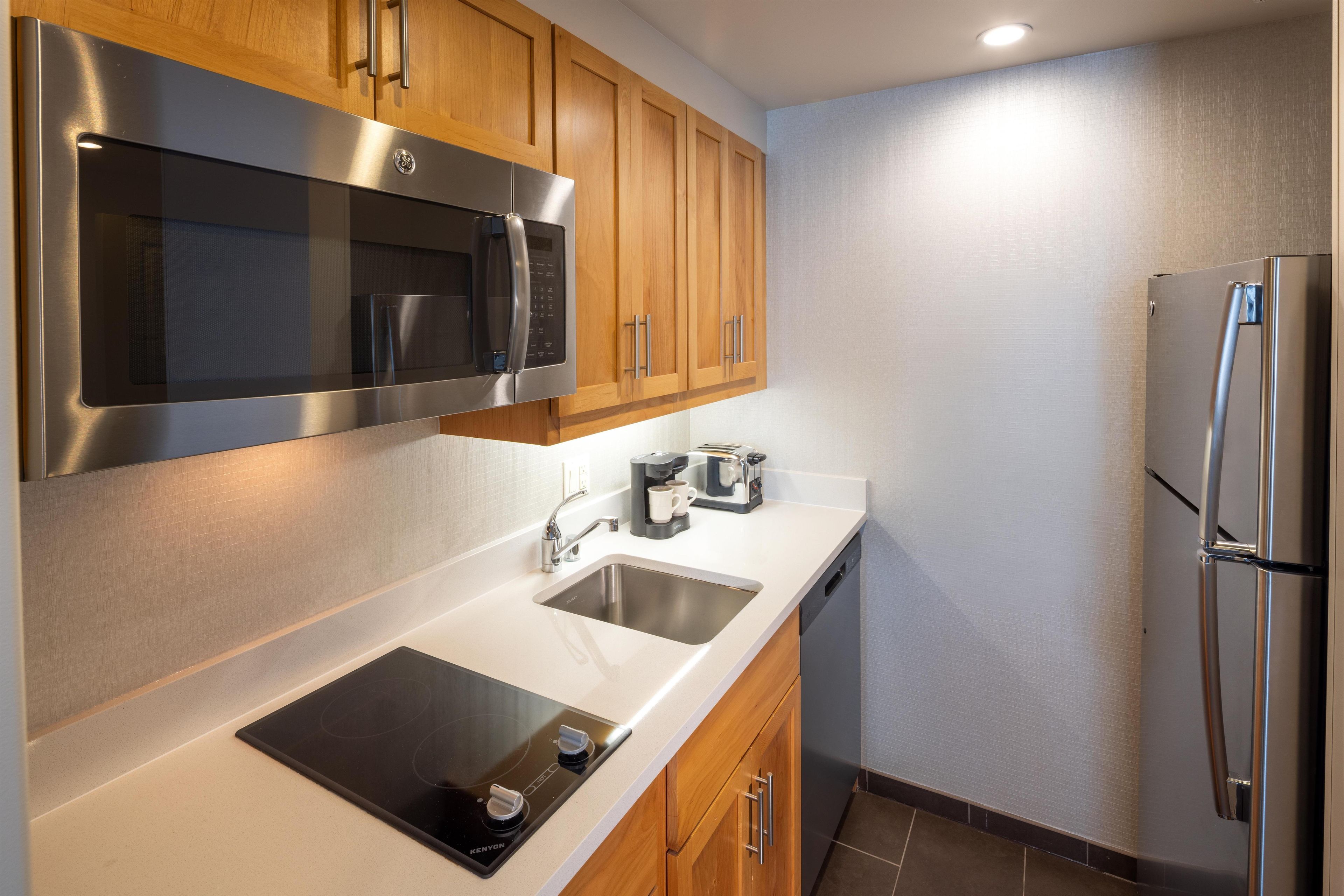 Una cocina moderna con electrodomésticos de acero inoxidable, un lavamanos doble y armarios de madera.