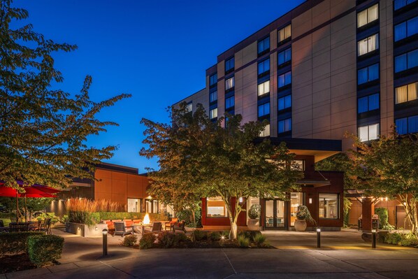 A modern hotel with a courtyard featuring outdoor seating, a fire pit, and well-maintained landscaping. - Homewood Suites by Hilton Seattle-Issaquah (Issaquah)