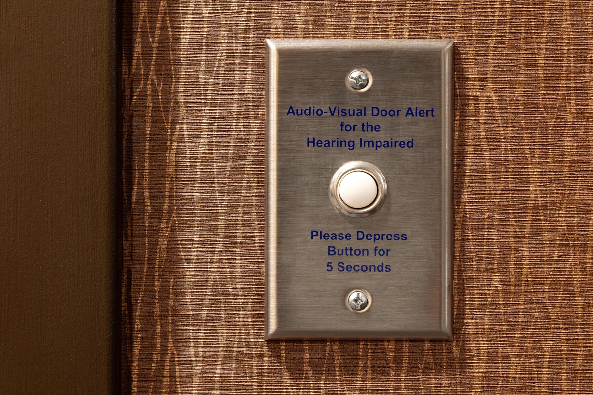 A door with an audio-visual alert system for the hearing impaired, including a depress button for 5 seconds.