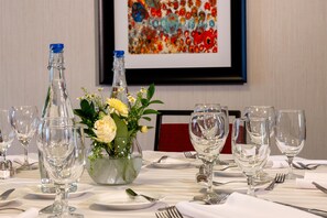 A dining table set with clear glassware, a floral centerpiece, and a framed artwork on the wall. - Homewood Suites by Hilton Seattle-Issaquah (Issaquah)