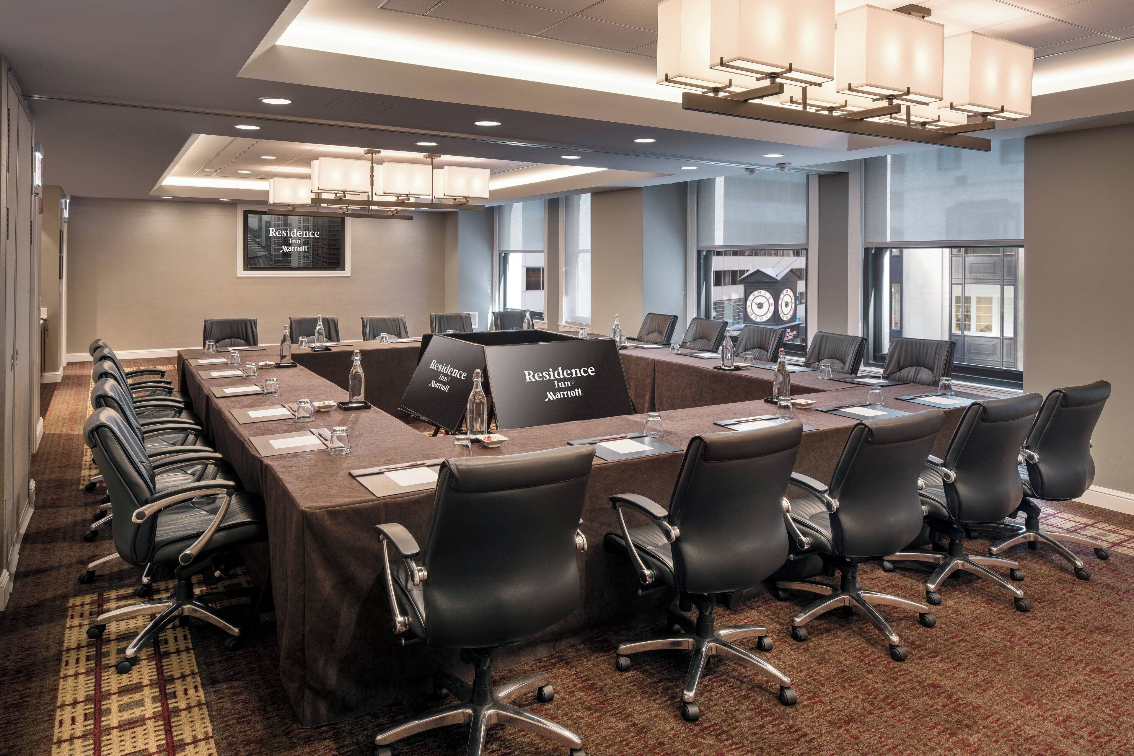 Une salle de conférence avec une longue table, de nombreuses chaises et une enseigne indiquant « Residence Inn Marriott ».