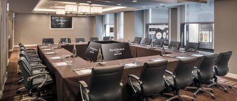 Une salle de conférence avec une longue table, de nombreuses chaises et une enseigne indiquant « Residence Inn Marriott ».