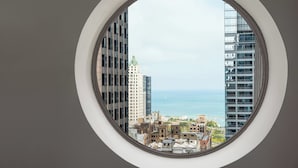 A view through a circular window of a cityscape with modern buildings and a body of water in the distance. - Residence Inn Chicago Downtown/Loop (Chicago)