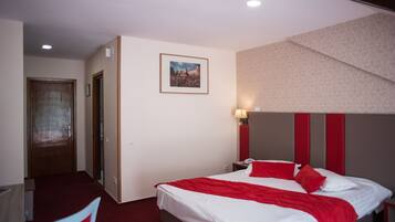 A hotel room with a bed, a desk, and a chair.