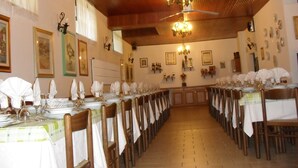 A long dining table with chairs, a chandelier, and wall-mounted decorations. - Hotel Ristorante Al Caminetto (Aosta)