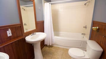 A bathroom with a pedestal sink, toilet, bathtub, and a shower curtain.