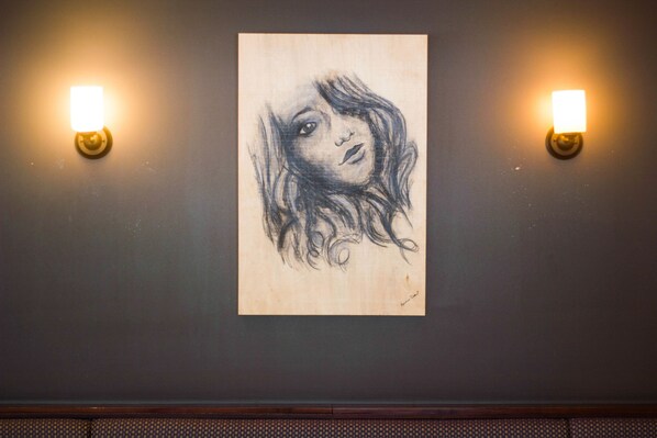 A wall with a framed drawing and two wall-mounted lights. - Hotel Marineau La Tuque (La Tuque)