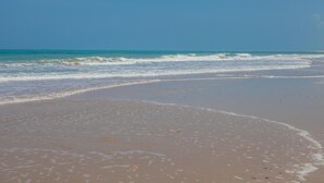Una playa con olas lamiendo suavemente la orilla.