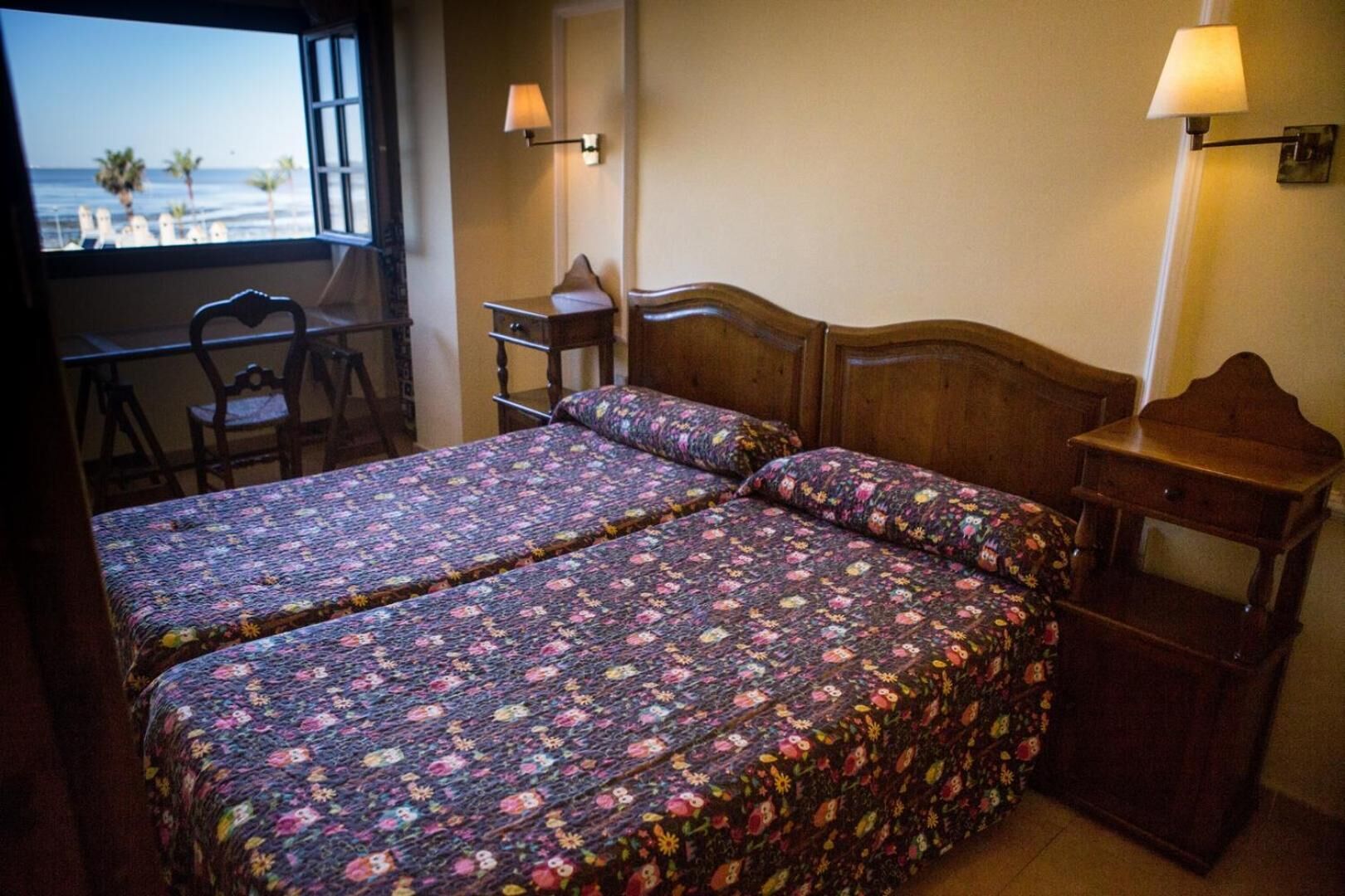 A room with two beds, a desk, and a chair.