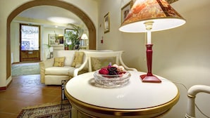 Un vestíbulo con una mesa redonda, un sofá color crema y una lámpara decorativa.