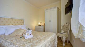 Ein Schlafzimmer mit Bett, Stuhl, Kleiderschrank und Fernseher.